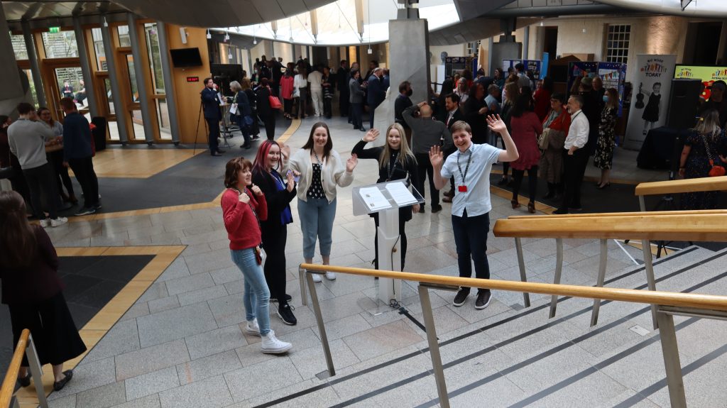 A group of young people standing on stairs in a building.